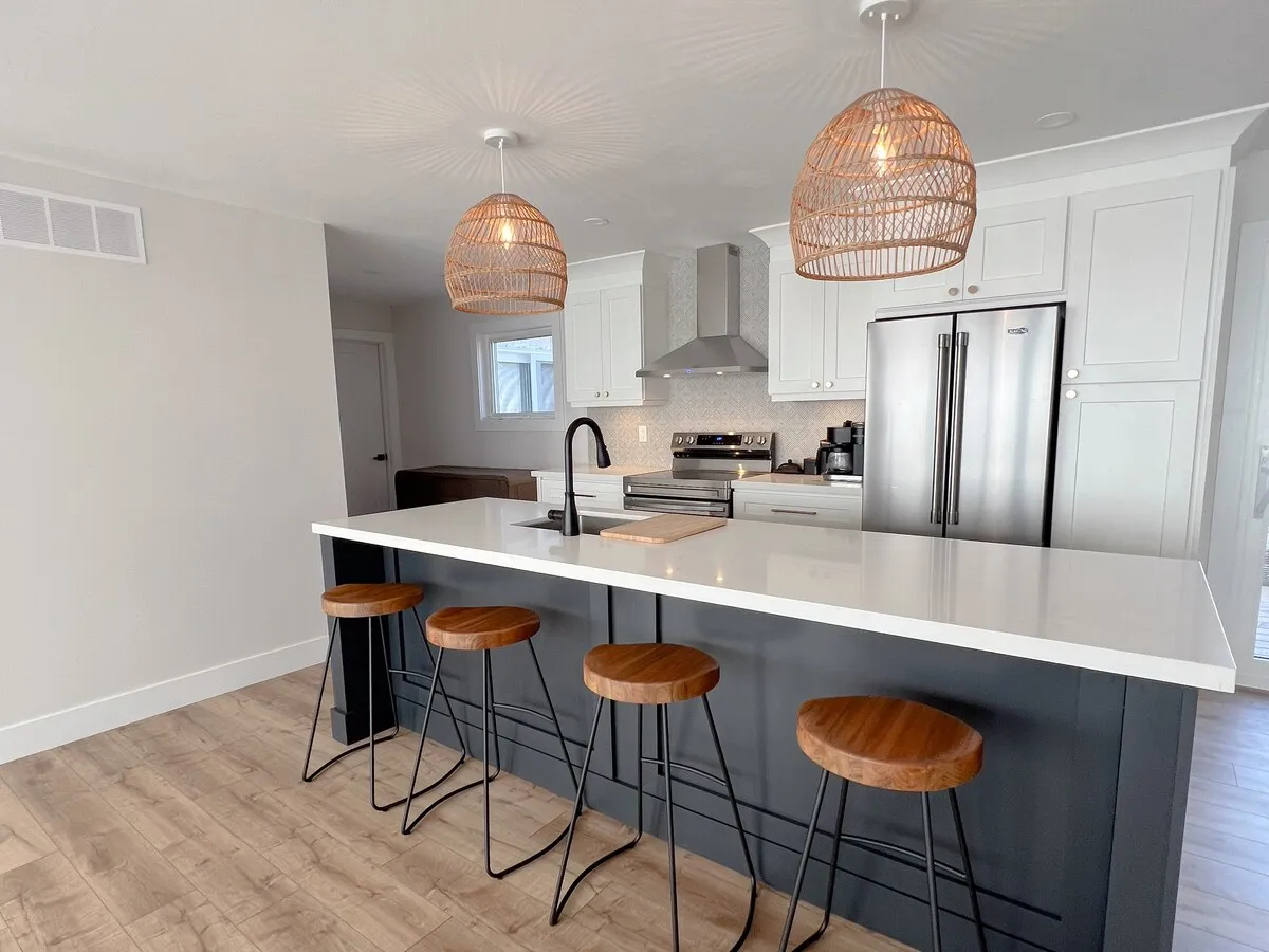 Kitchen with island and bar stools at Cedar cottage