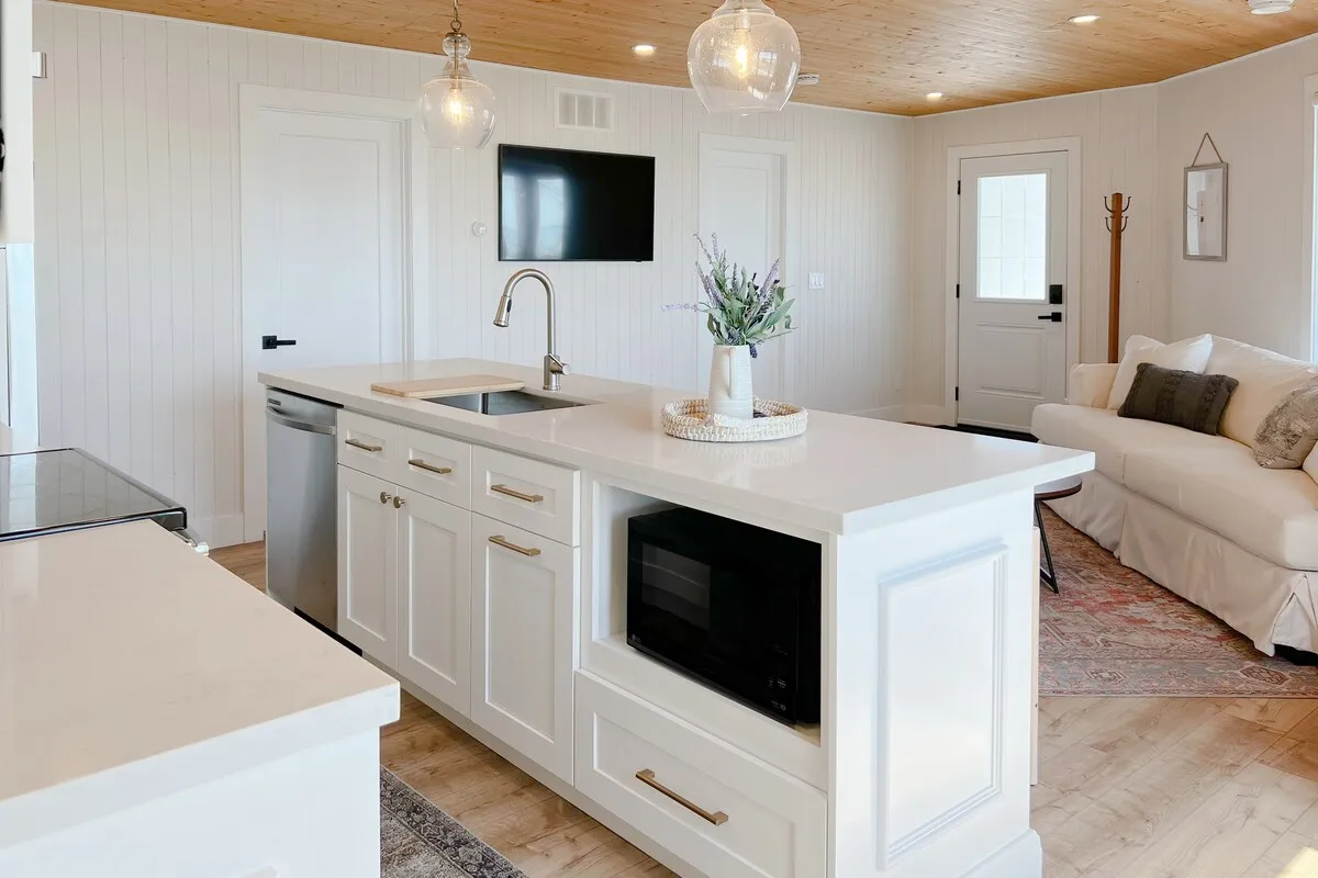 White kitchen with island at Tiki cottage