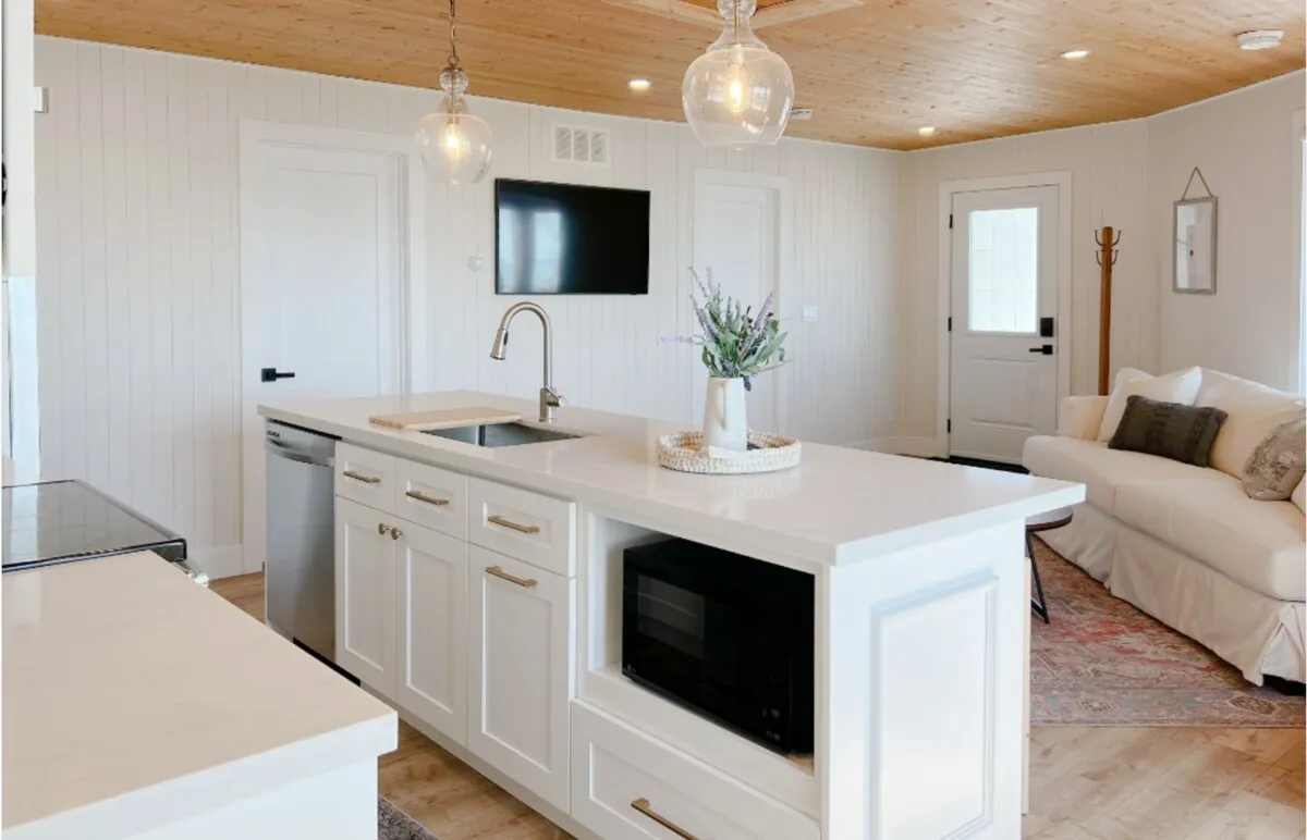 White kitchen with island in the Tiki side of the Cedar + Tiki Suite
